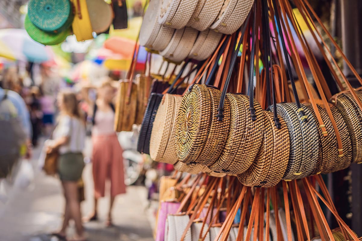 Various bags and accessories hanging in front of the street stalls